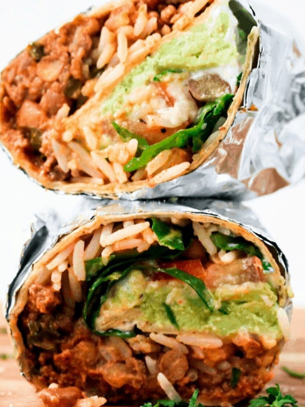 Ground beef burrito wrapped in foil stacked.
