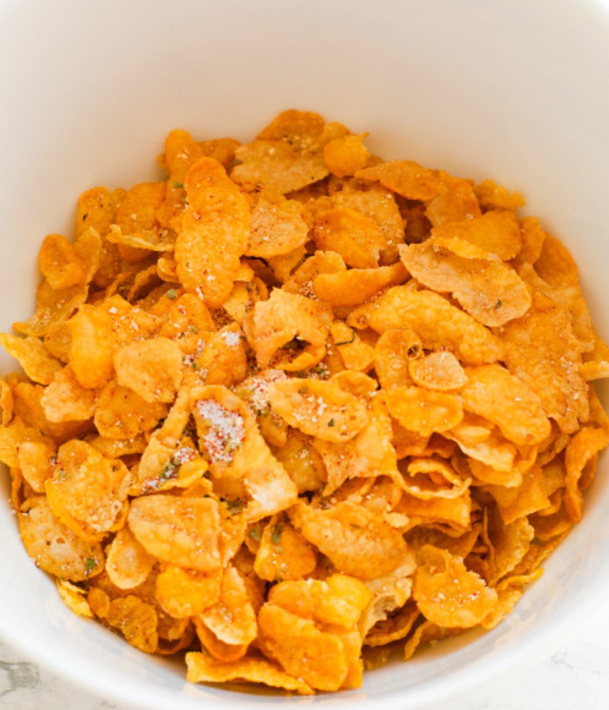 Cornflakes, salt and black pepper in a white bowl.