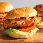 Crispy chicken in a bun with tomato, lettucw and burger sauce.