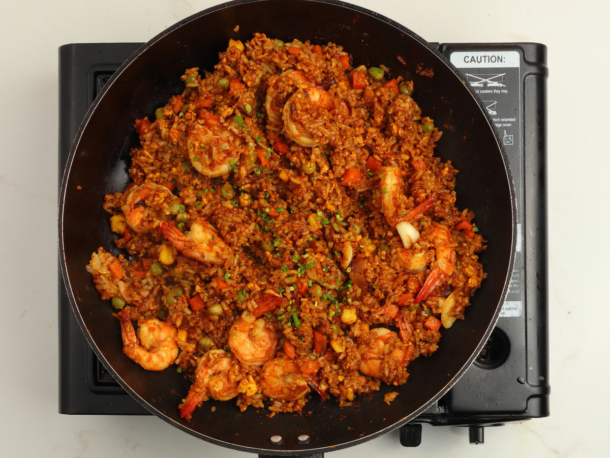 Mixed vegetables, leftover white rice, soy marinade and eggs mixed in a black pan.