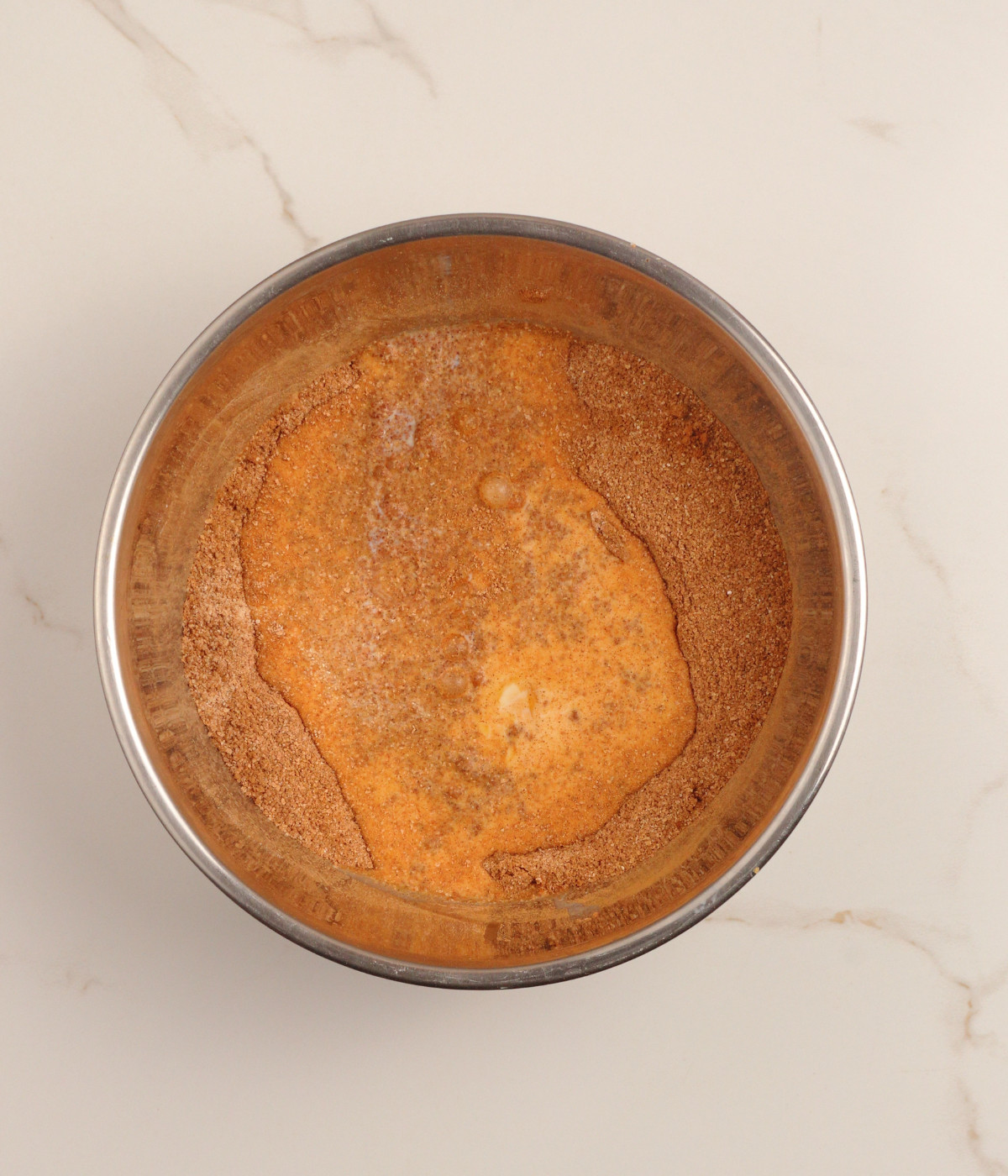Flour and cocoa powder mixture and egg mix in a silver bowl.