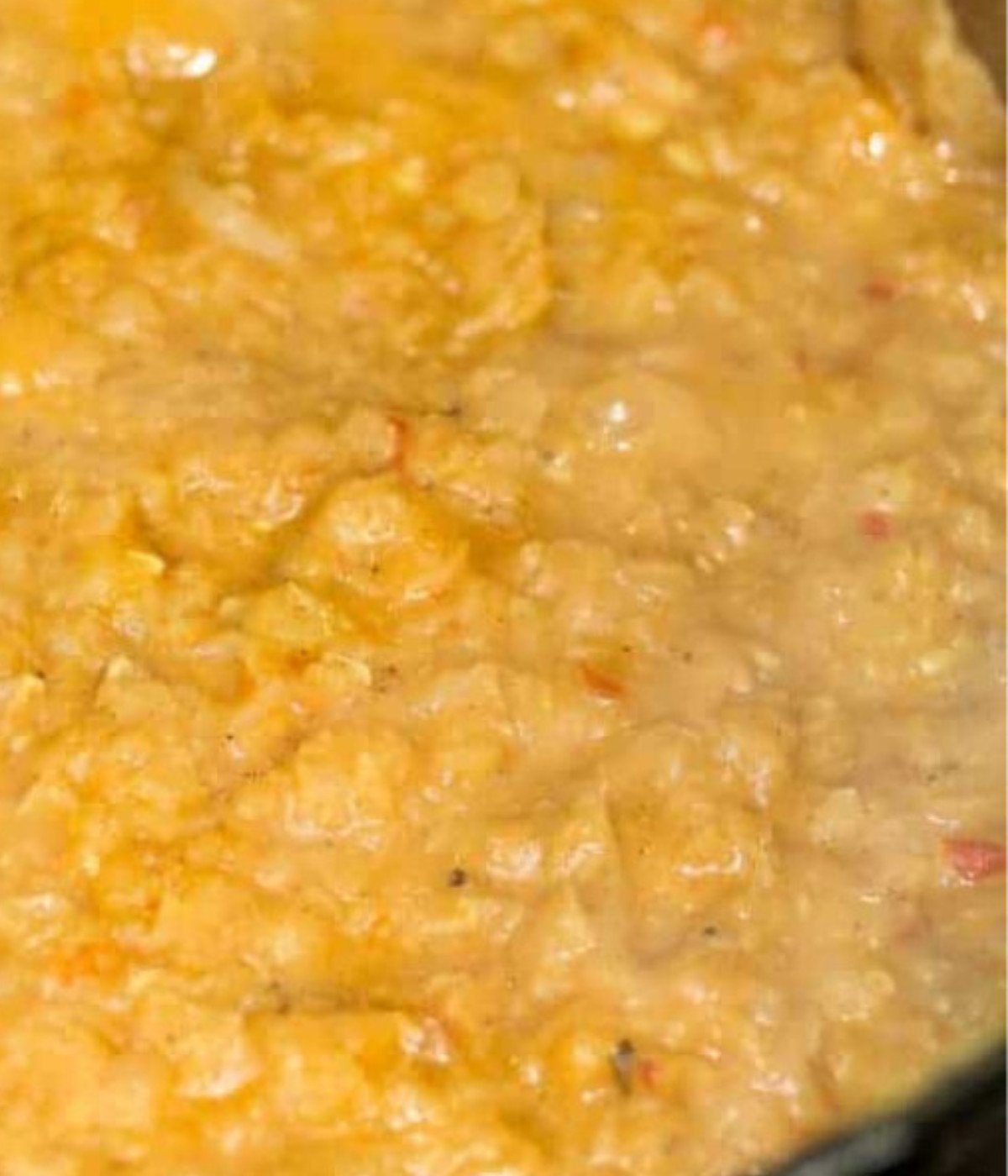 Red lentils, blended tomatoes and coconut milk in a pot.
