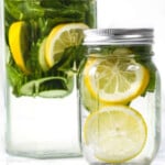 Lemon slices, mints leaves and water in a glass jar and jug.