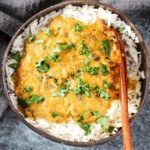 vegan red lentil curry in a brown coconut bowl