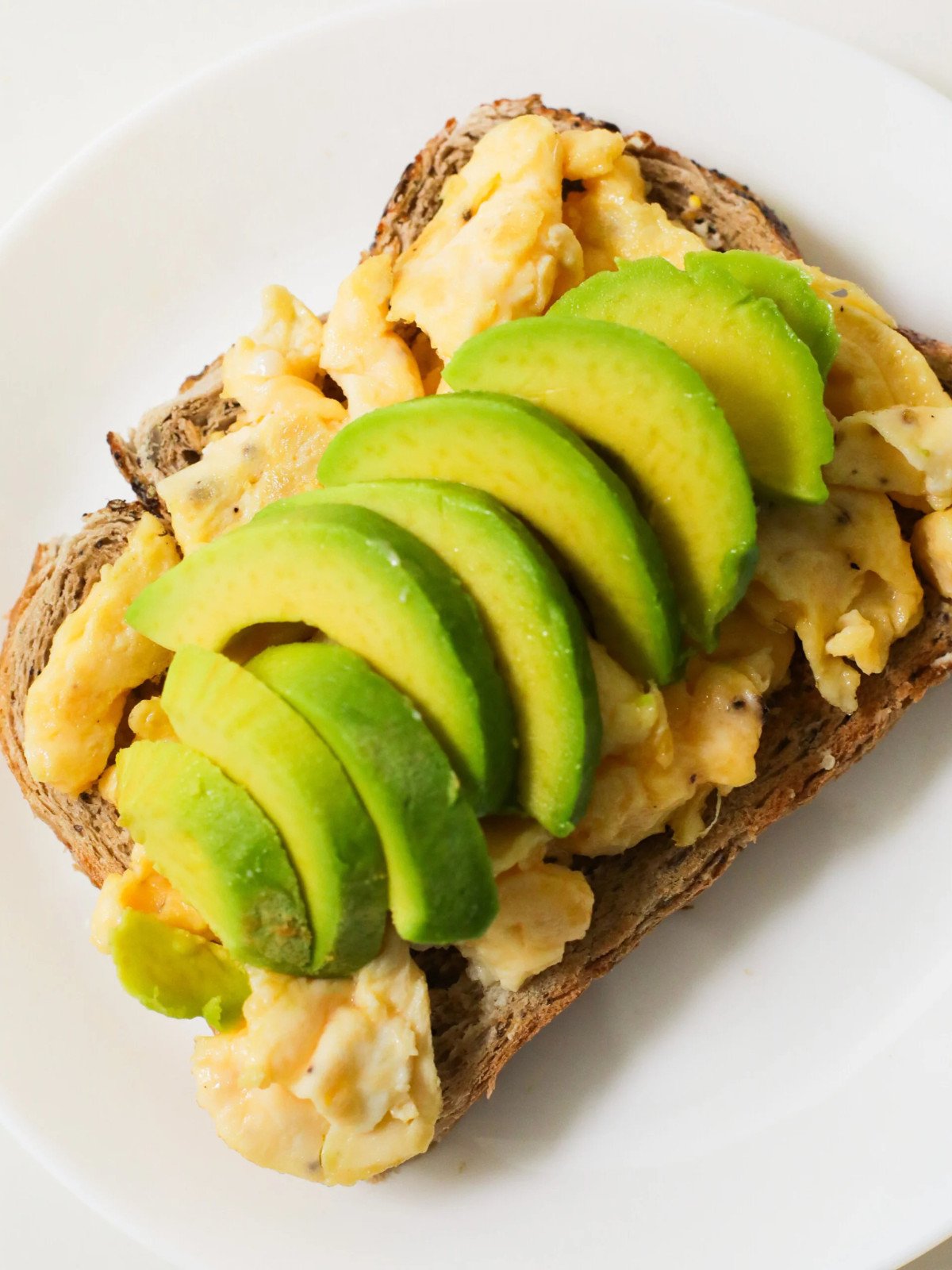 Egg on toast with sliced avocado.