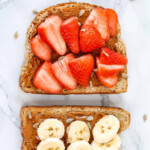 Strawberry slices on brown bread with nut butter.