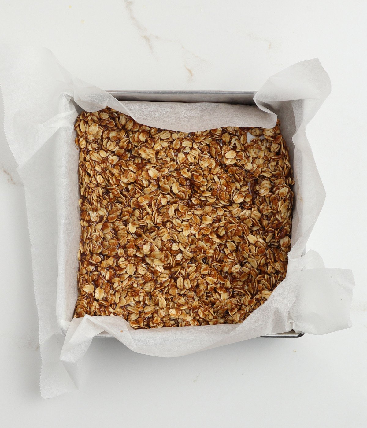 Add oat mixture to a lined square silver tin.