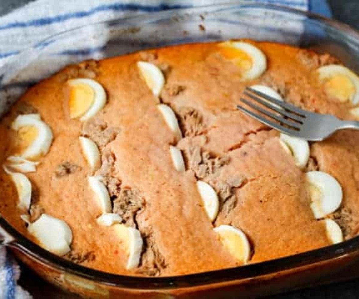 Moin moin, eggs and fish baked in a glass oven dish with a fork on top.