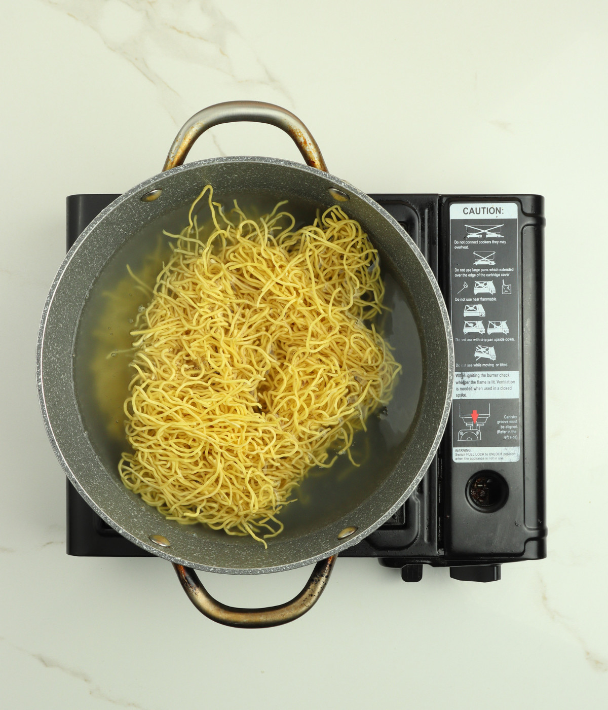 Chow mein noodles and water in a pot.