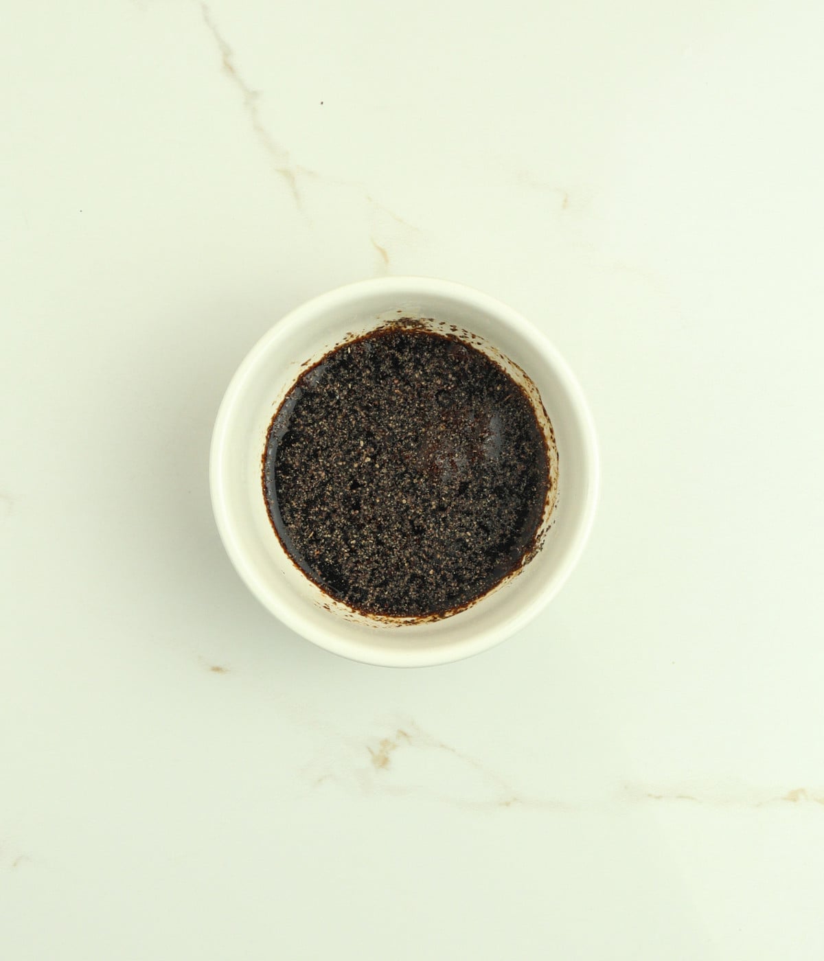 Soy sauce, sesame oil, honey, and black pepper mixed in a white bowl.