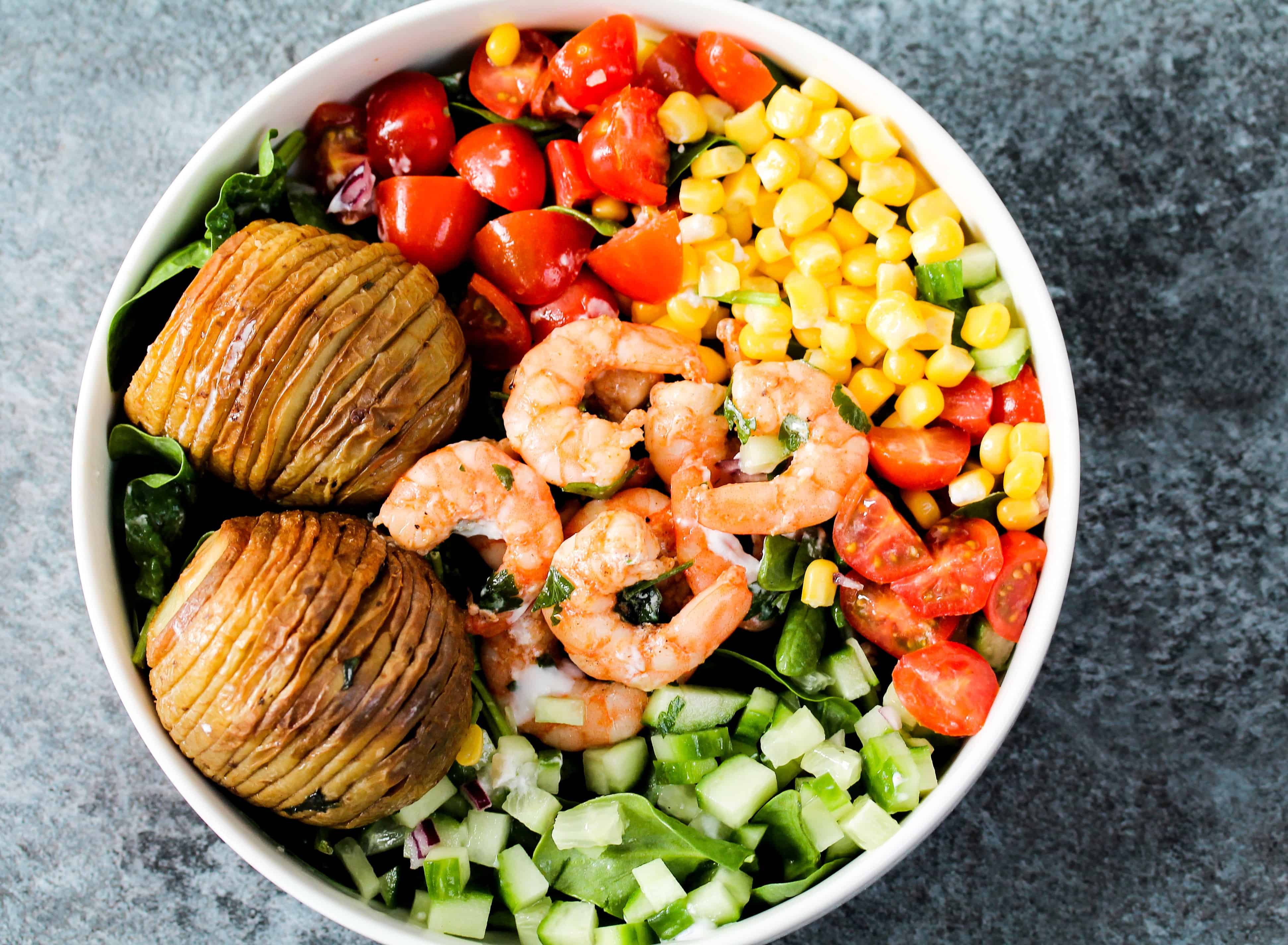 hasselback-potatoes-served-with-prawns-and-veggies