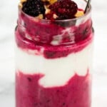 Berry sauce and yogurt in a glass jar.