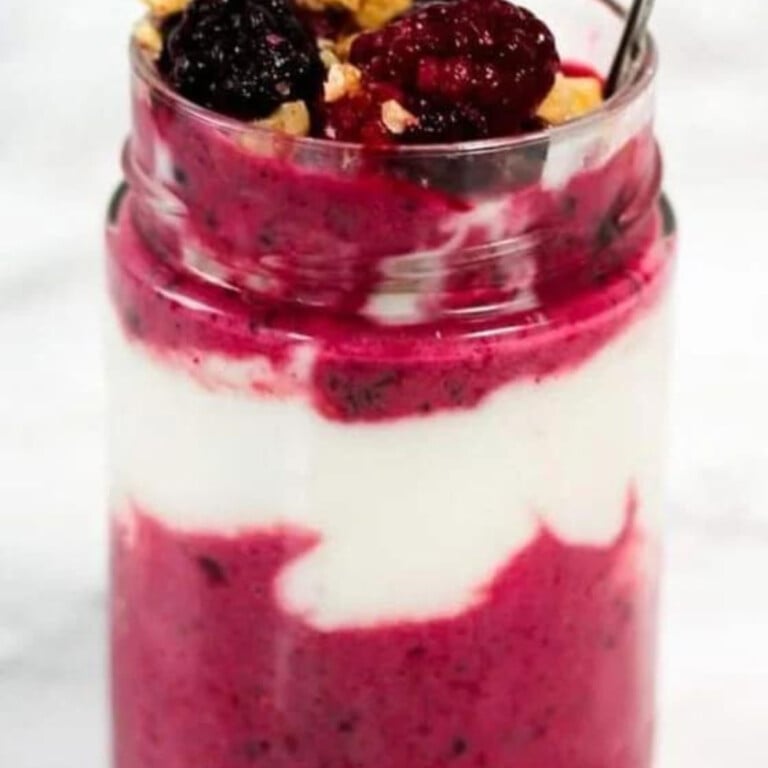 Berry sauce and yogurt in a glass jar.