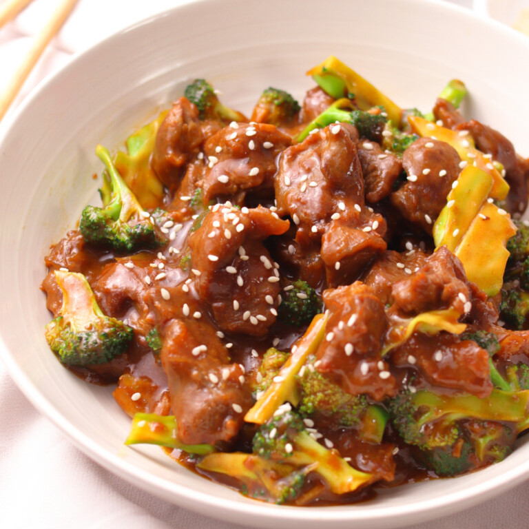 Chinese style beef, broccoli and sesame seeds in a white plate.