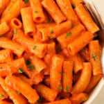 Creamy tomato rigatoni pasta garnished with parsley.