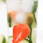 Strawberry, ice, water and cucmbers in a glass cup.