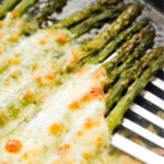 Asparagus with melted cheese on top.