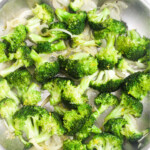 Broccoli florets, lemon zest, onions and a silver pan.