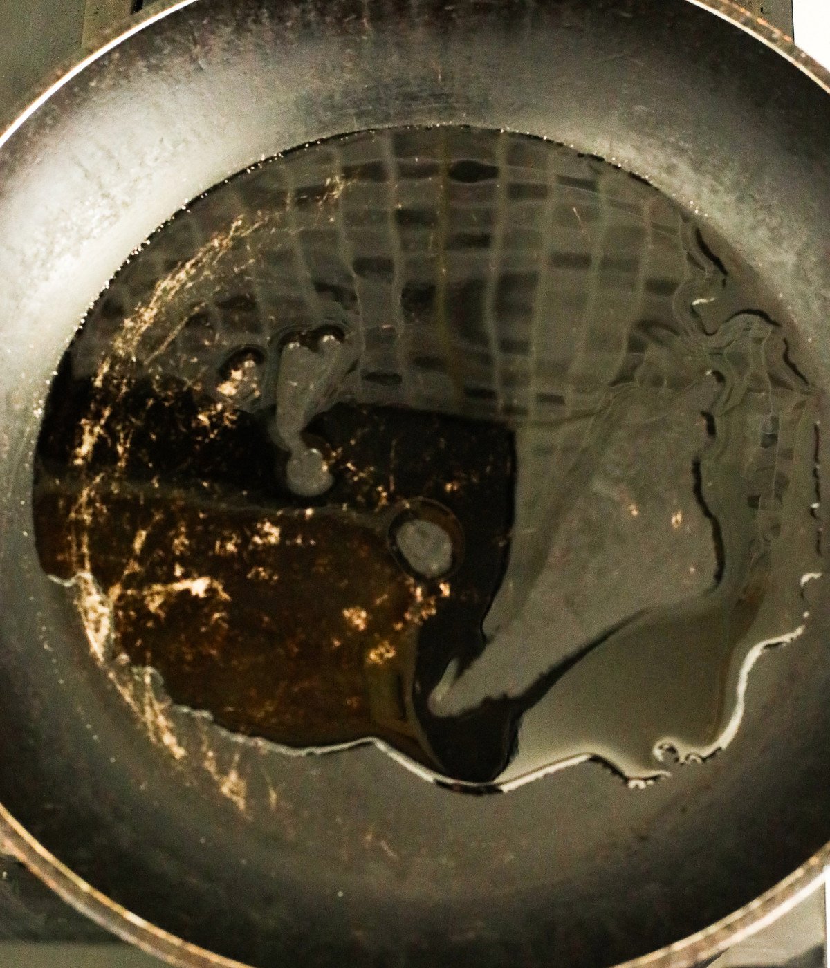 Oil heated in a black pan.