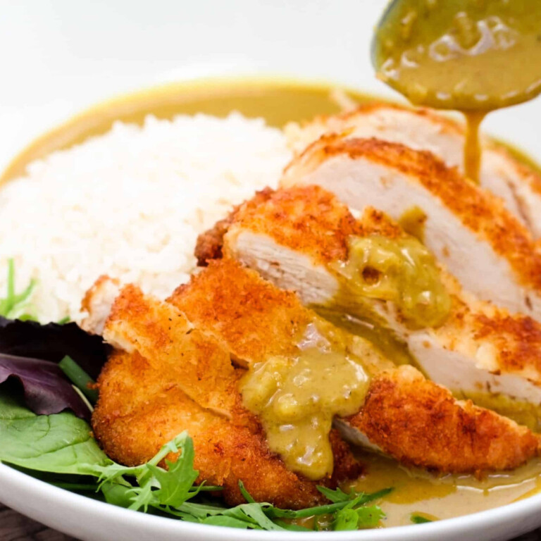 Panko chicken in a curry sauce with white rice and lettuce.