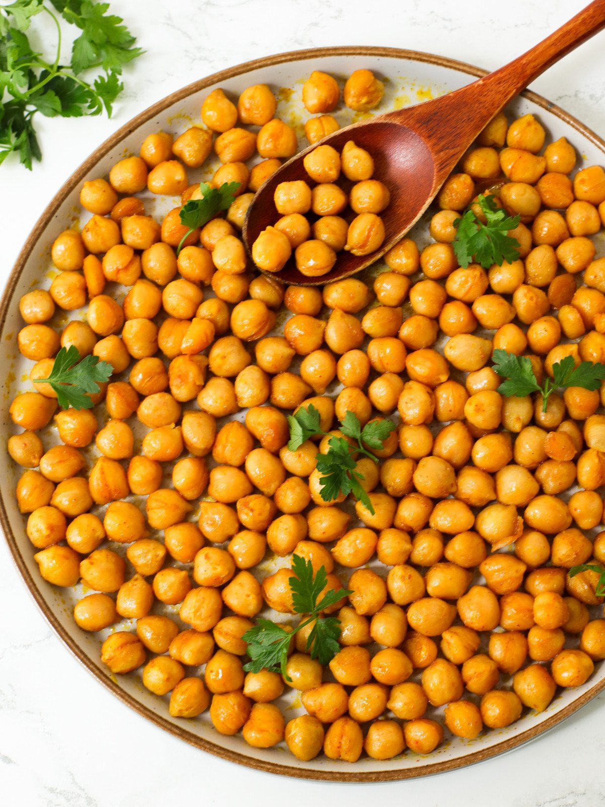 Seared chickpeas with herbs on top in a plate.