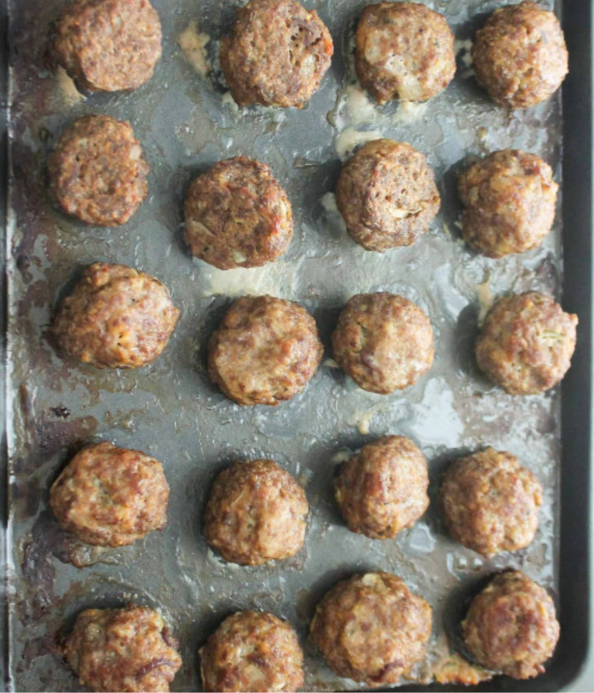 Baked meatballs on a lightly greased baking tray.