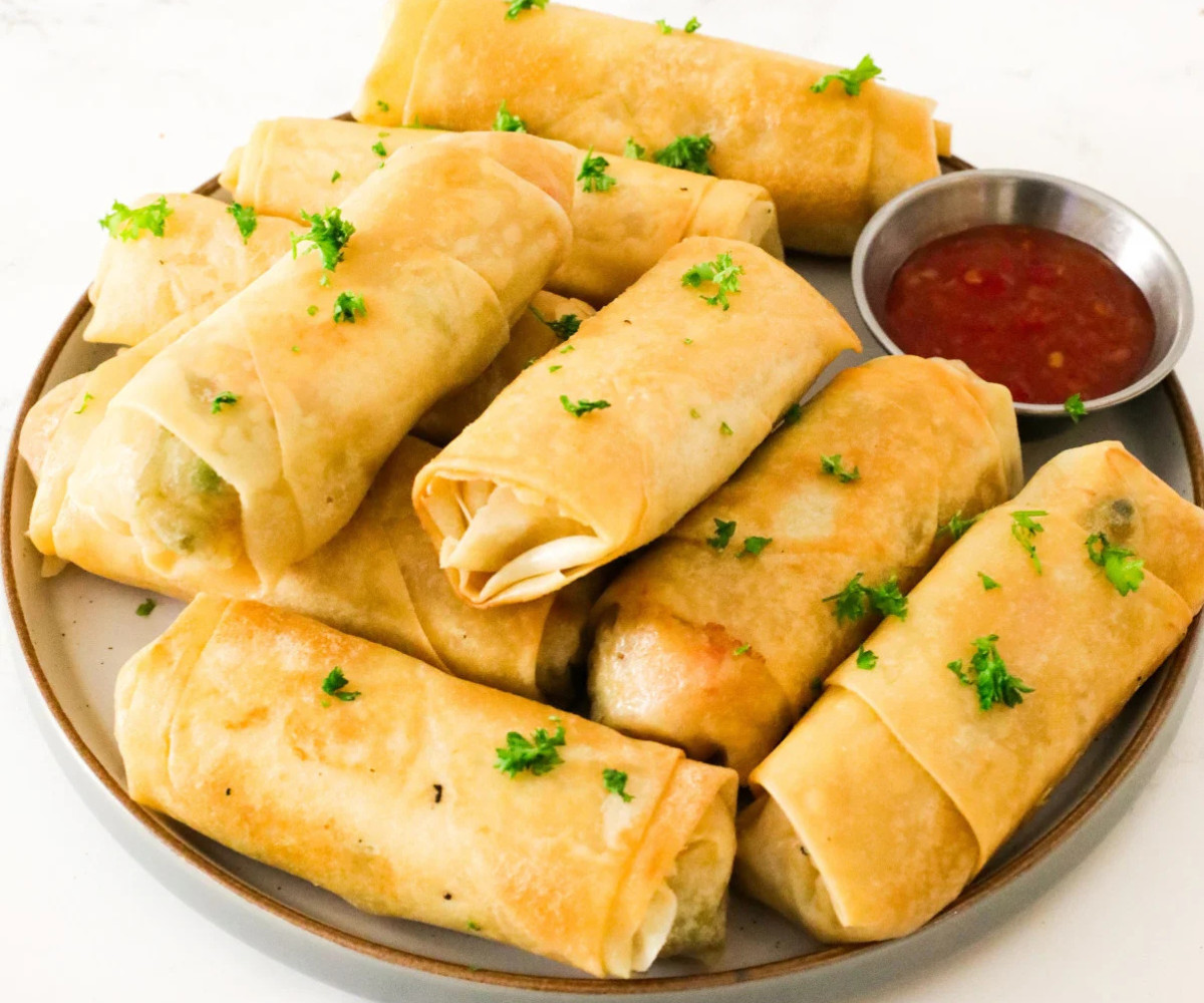 Chinese spring rolls on a plate with sweet chili sauce. 