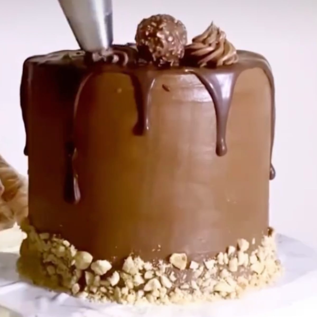 Chocolate ferrero cake with milk chocolate ganache, crushed hazelnuts.