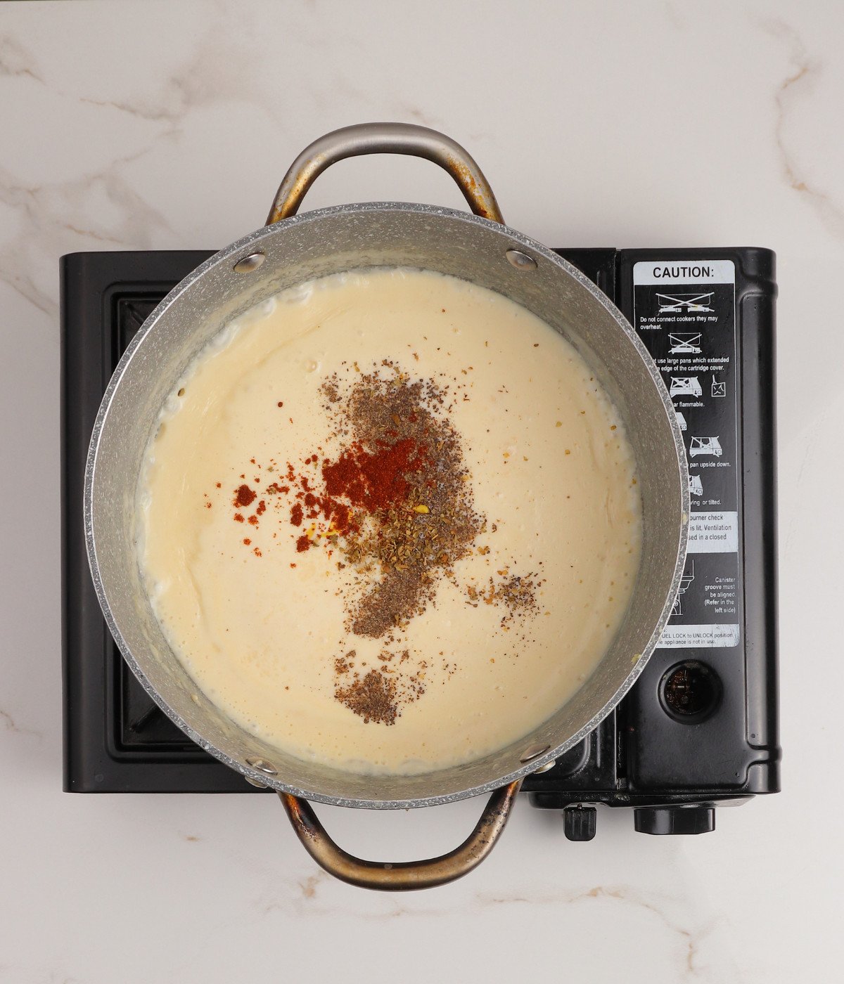 Creamy roux, salt, paprika, salt, black pepper, mustard and oregano in a pot.