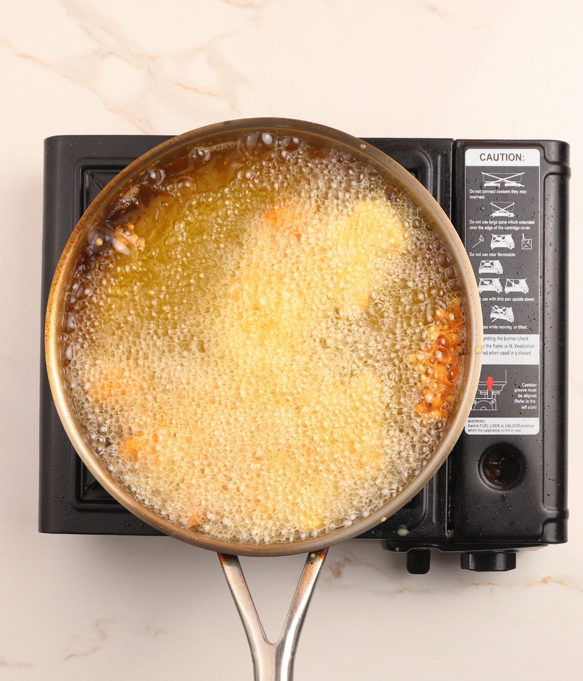 Chicken pieces frying in hot oil.