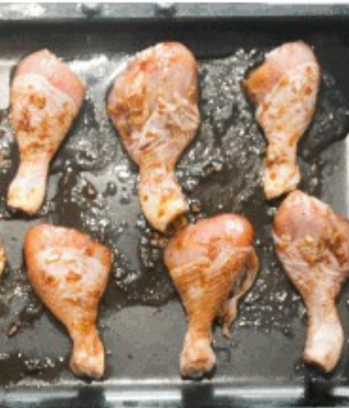 Honey soy chicken drums on a lightly greased oven tray.