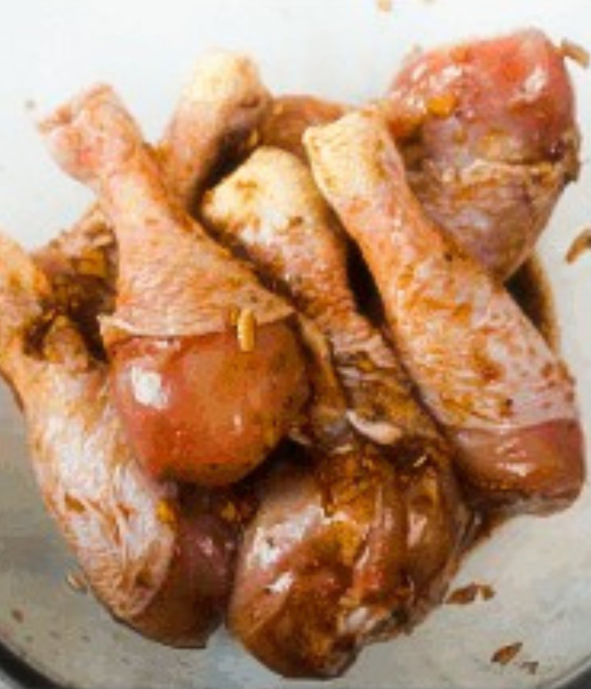 Honey soy marinade rubbed into uncooked chicken drums.