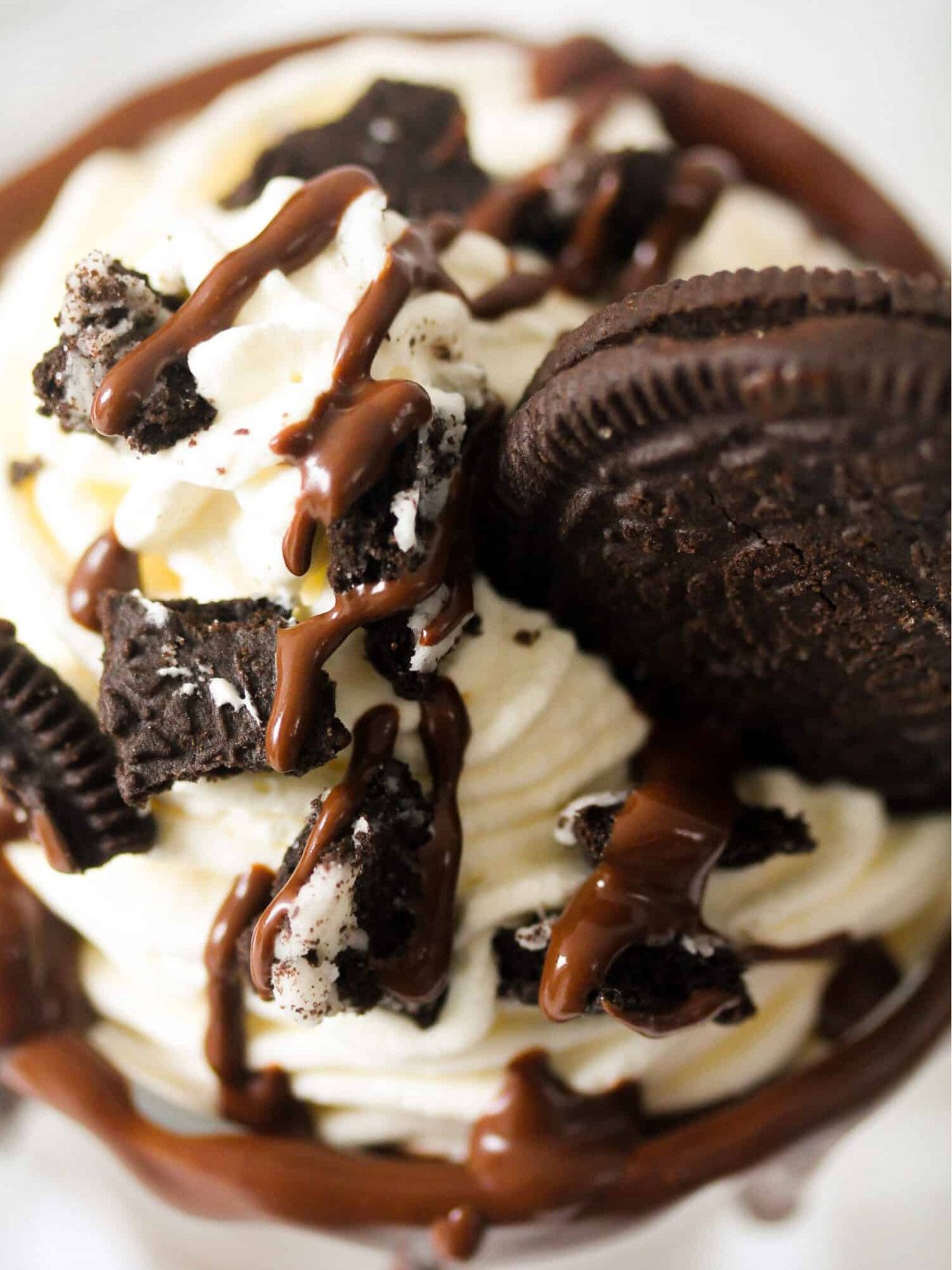 Oreo milkshake topped with whipped cream and chocolate sauce.