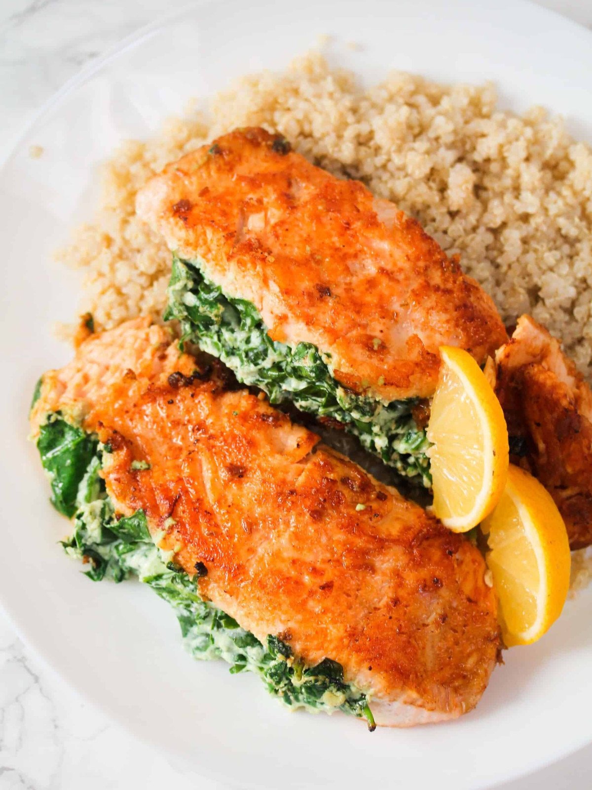 Salmon fillet with ricotta and spinach inside on bulgur wheat.
