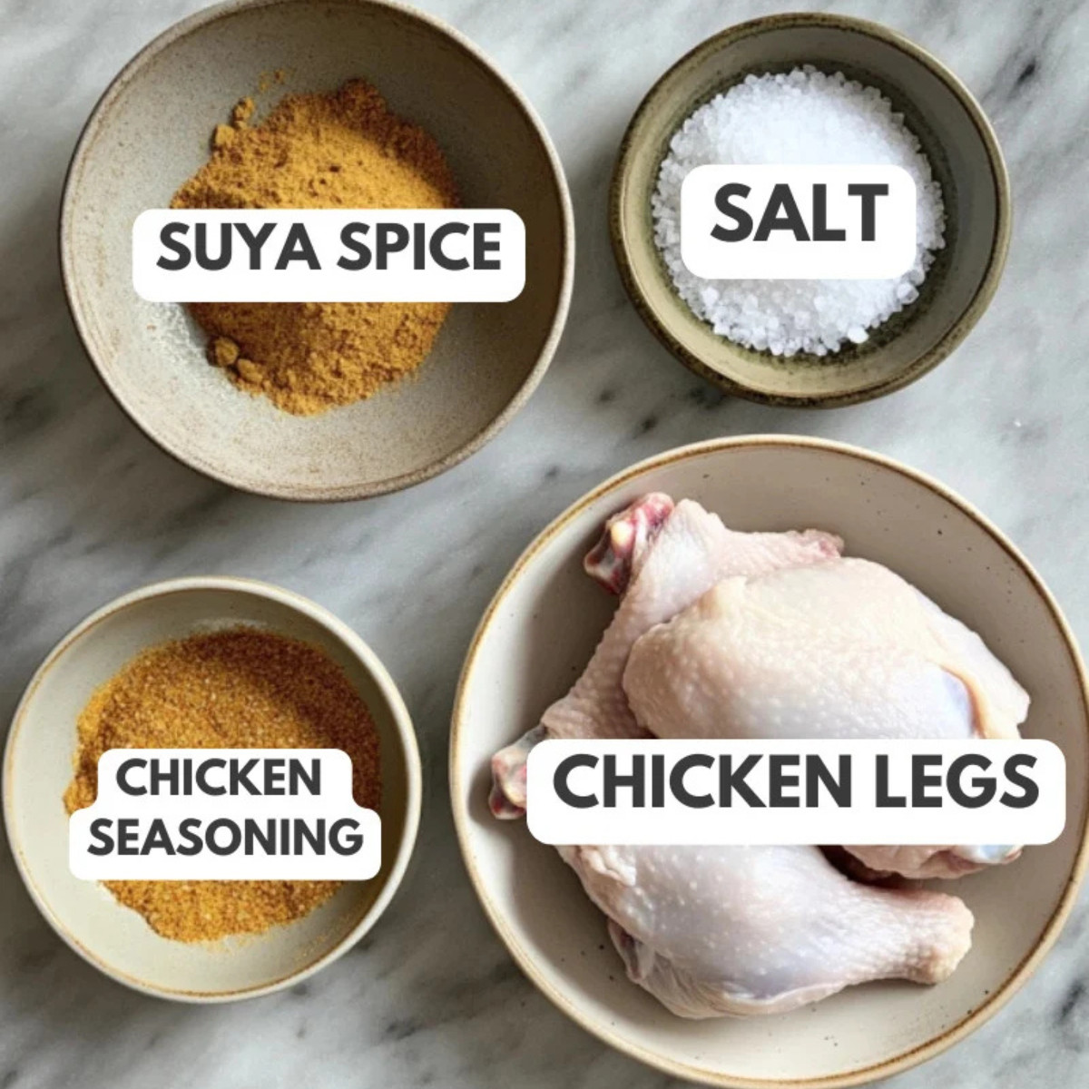 Suya spice, salt, chicken legs and chicken seasoning on a table.