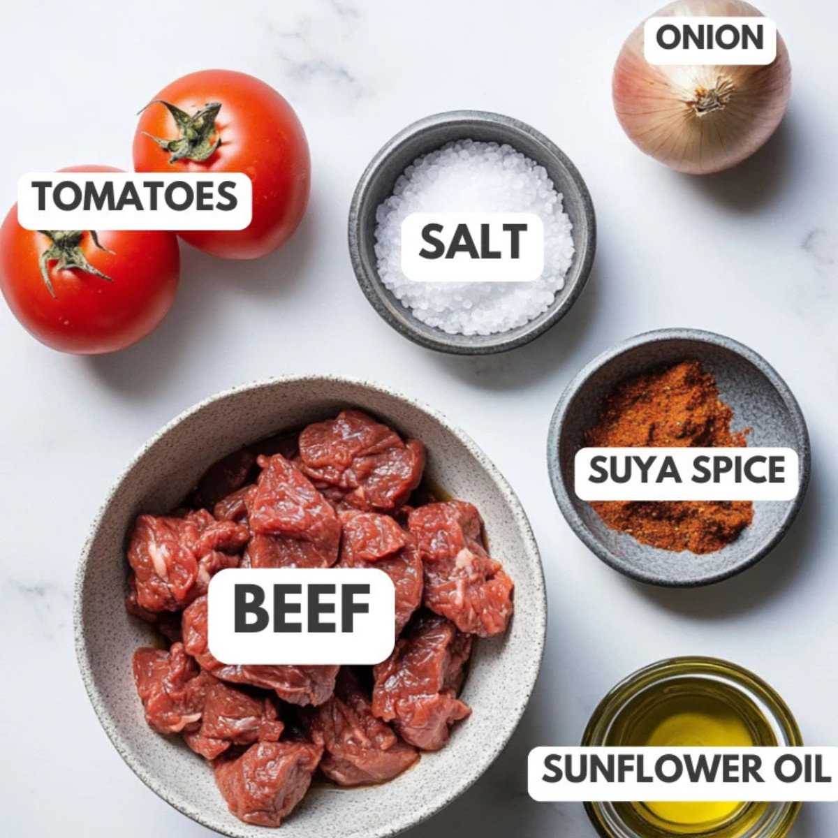 Tomatoes, salt, onion, suya, beef, and oil on a table.
