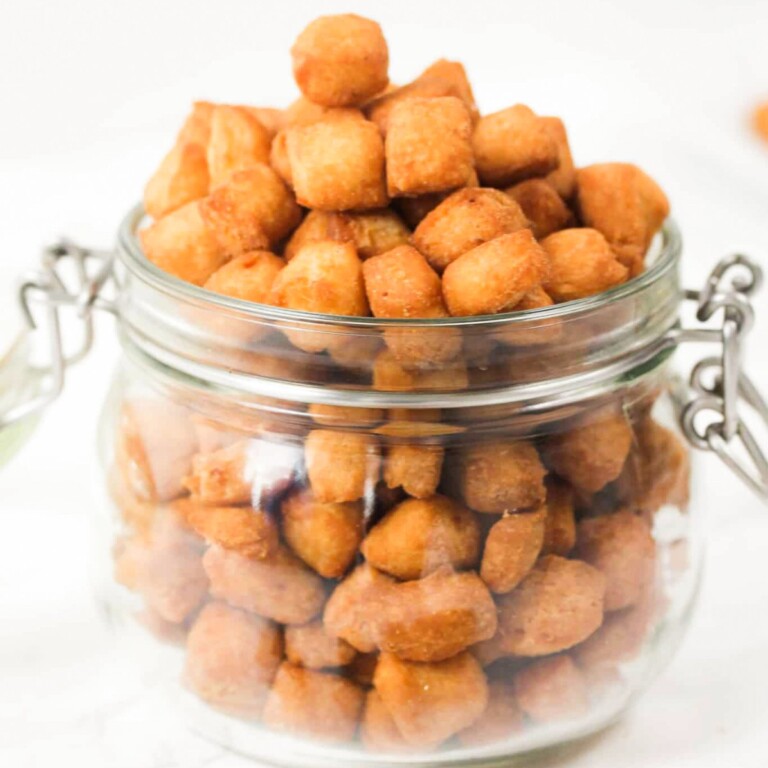 Nigerian chin chin in a glass jar on a white table.