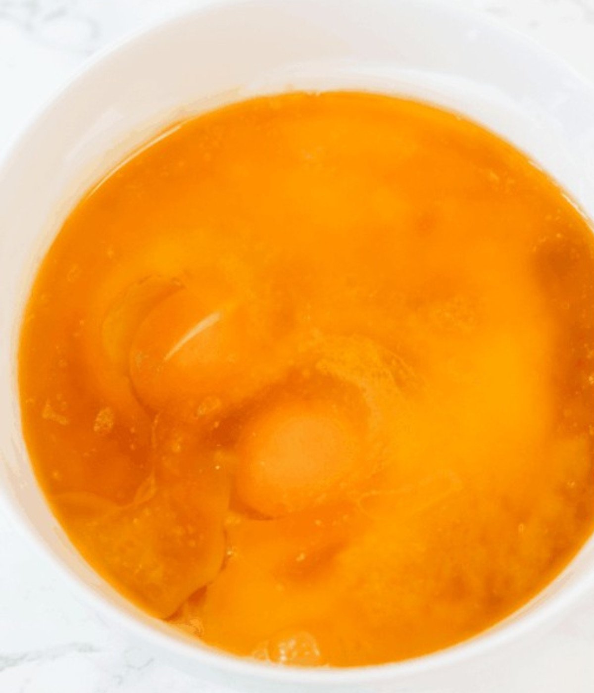 Beaten eggs in a white plate.