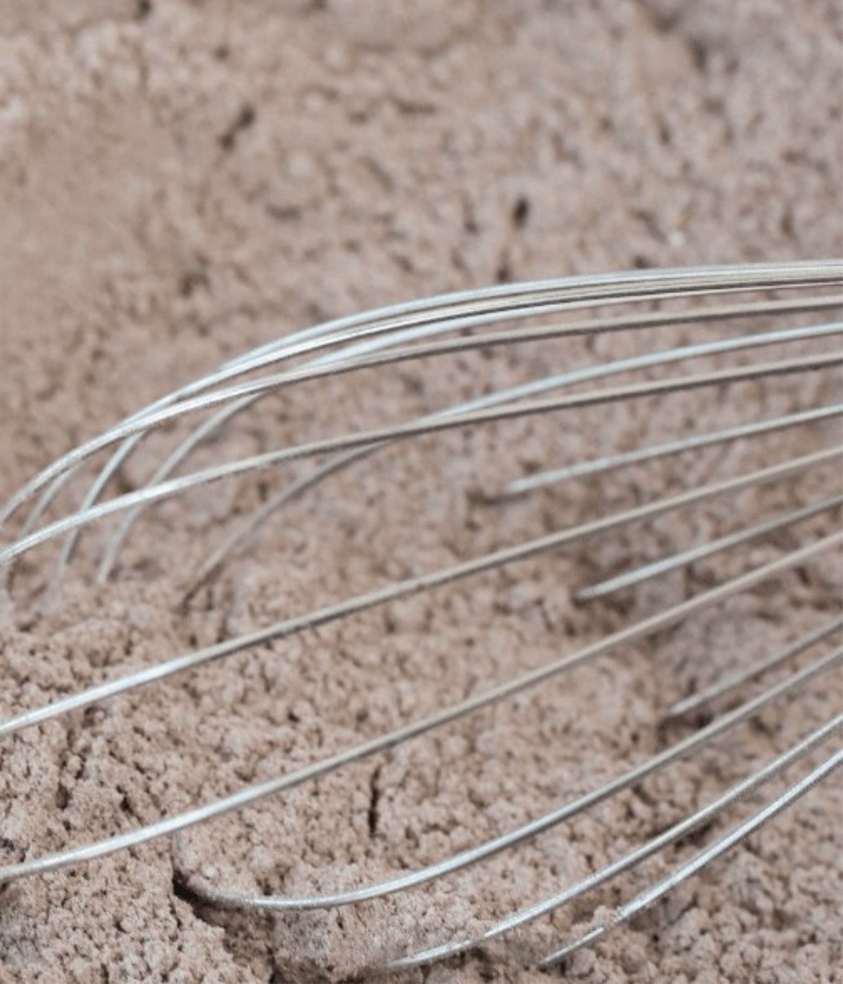 Cocoa powder and flour whisked in a bowl.