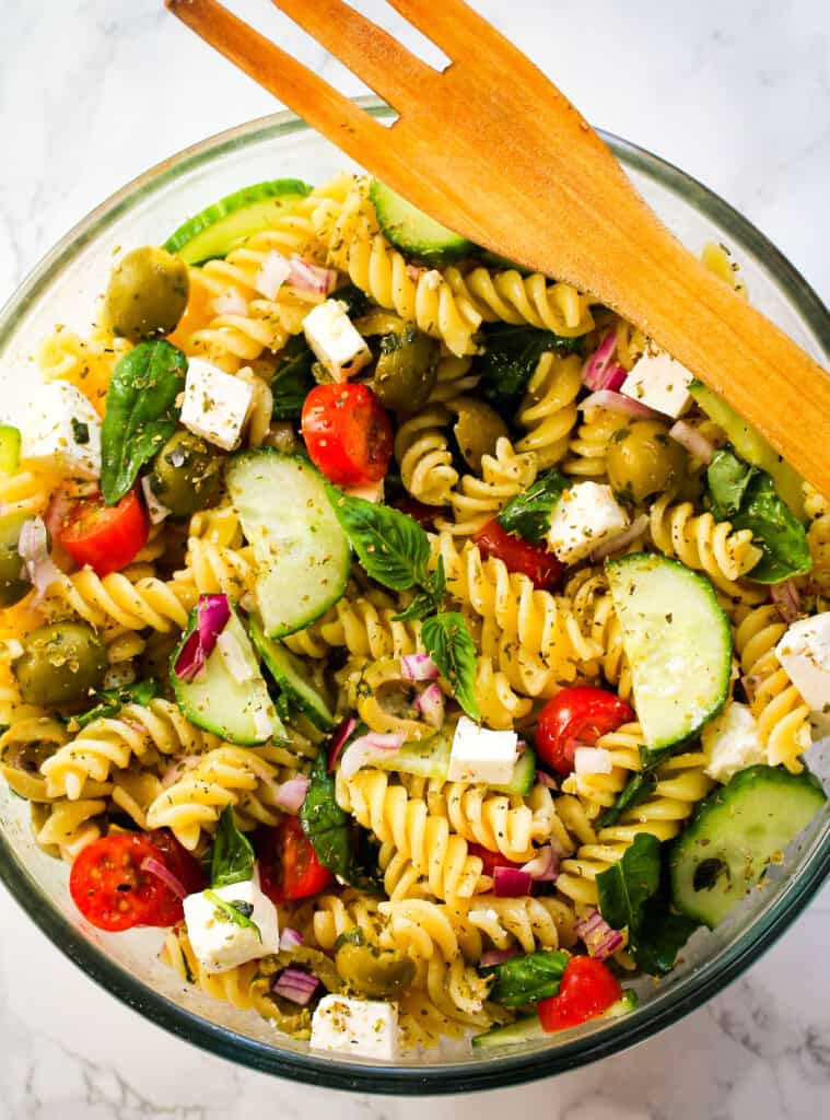 Mediterranean pasta salad in a bowl with a wooden fork