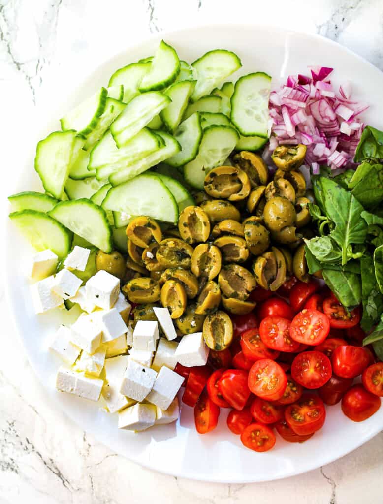 Mediterranean salad ingredients on white plate