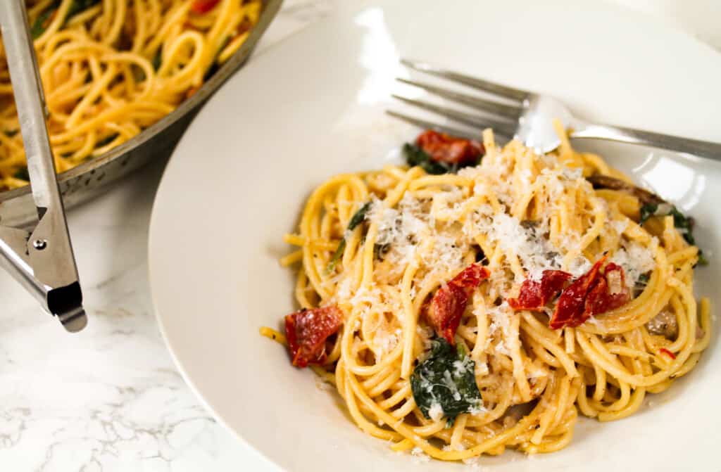 creamy mushroom, sun-dried tomatoes, spinach pasta in a plate