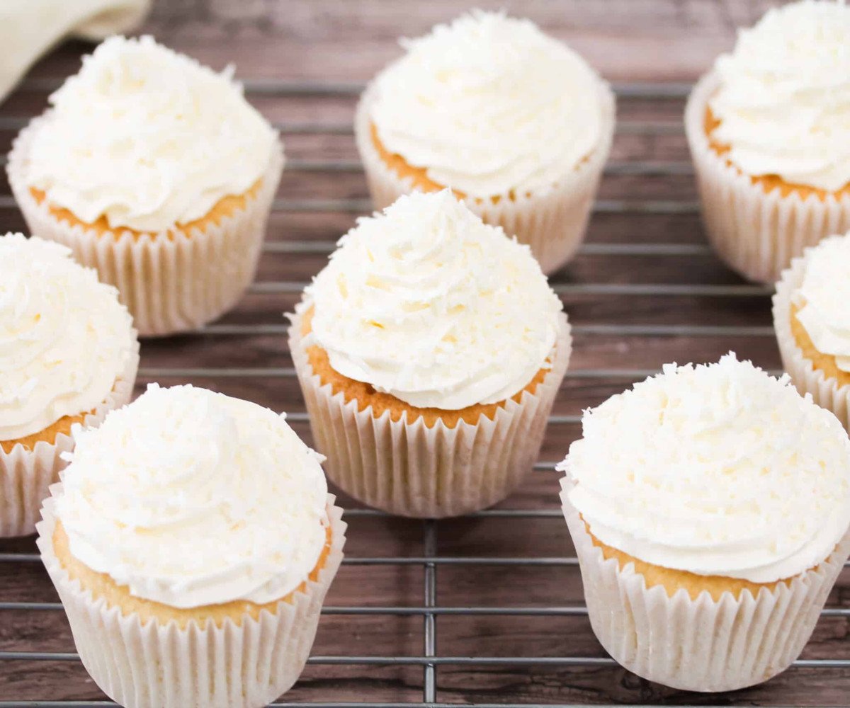 Coconut cupcakes on a cooling rack.