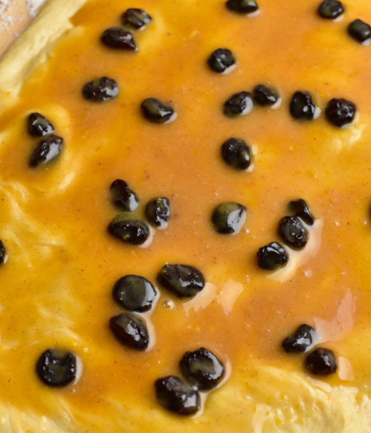 Fruit curd and raisin spread on dough.