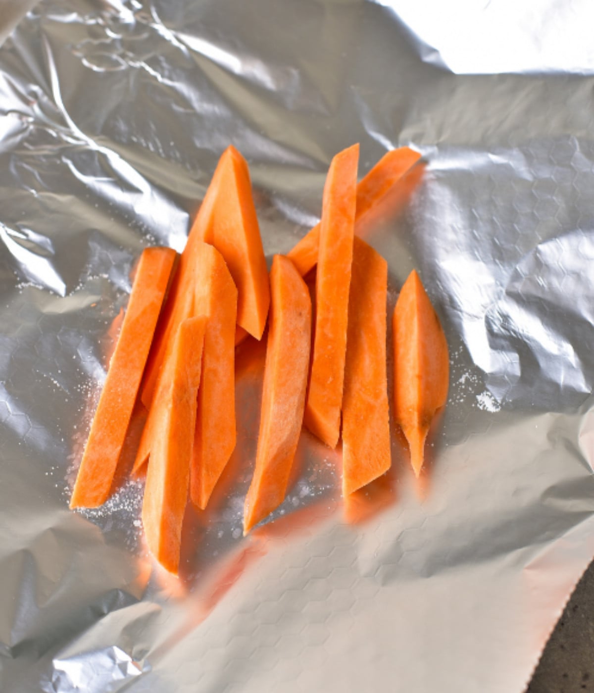 Chopped sweet potatoes on foil.
