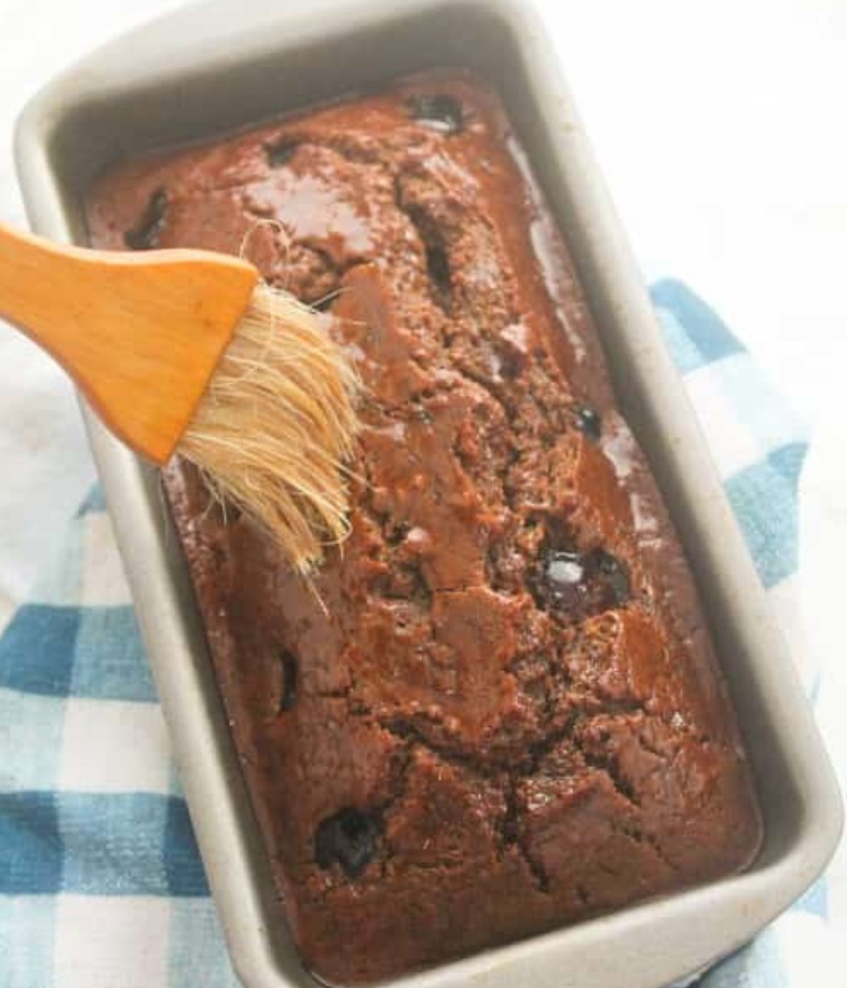 Baked Jamaican buns with cherries on top in a loaf tin brushed with syrup.