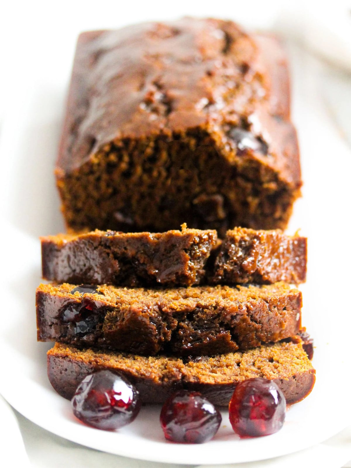 Jamaica Easter bun on a white plate with cherries.
