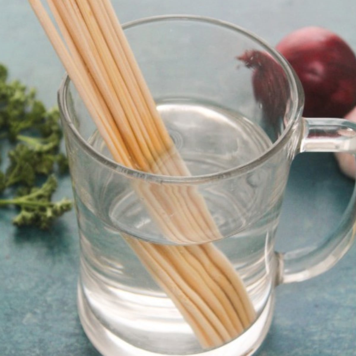 Kebab sticks soaked in a glass cup of water.