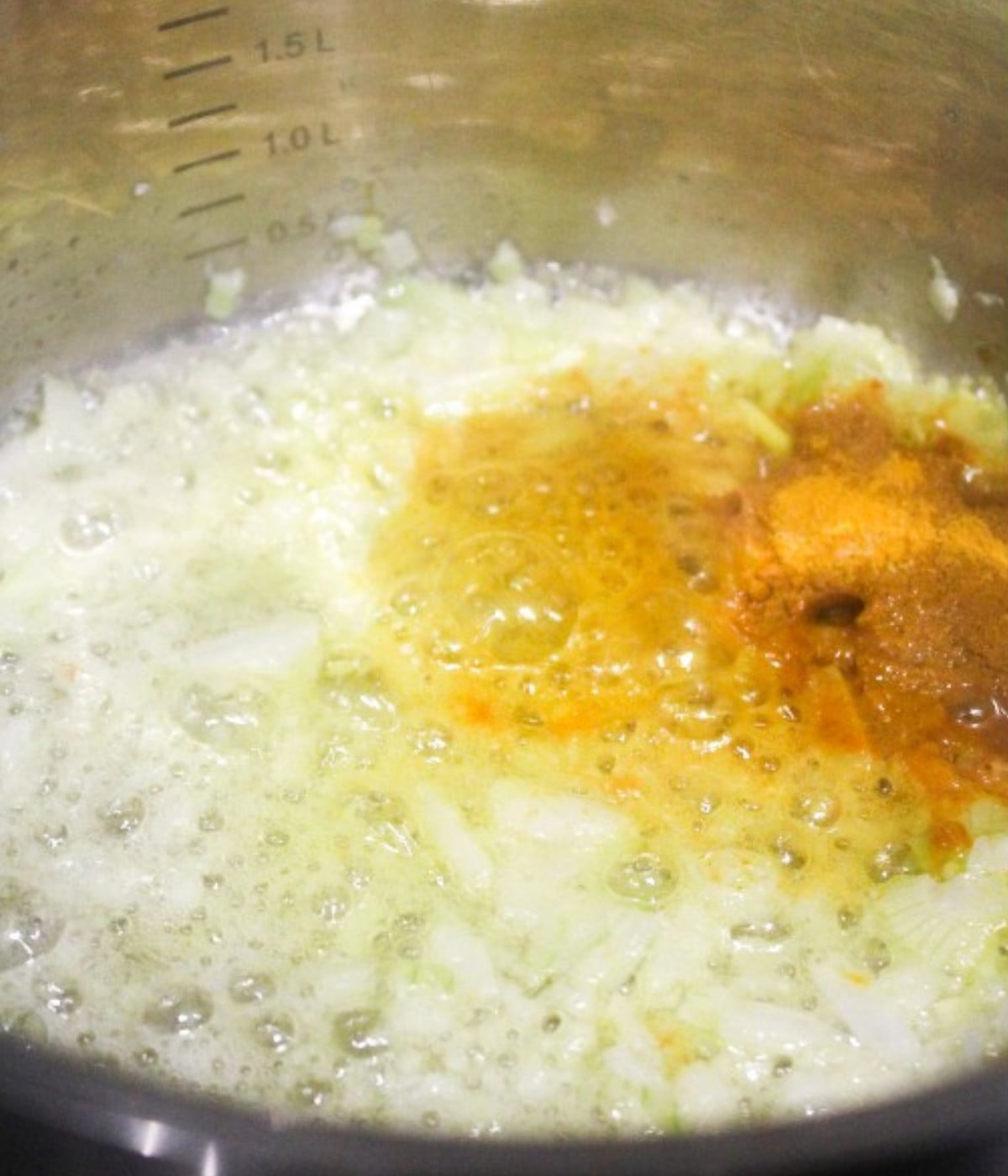 Butter melted, garlic, turmerc and chopped onions in a silver pot.