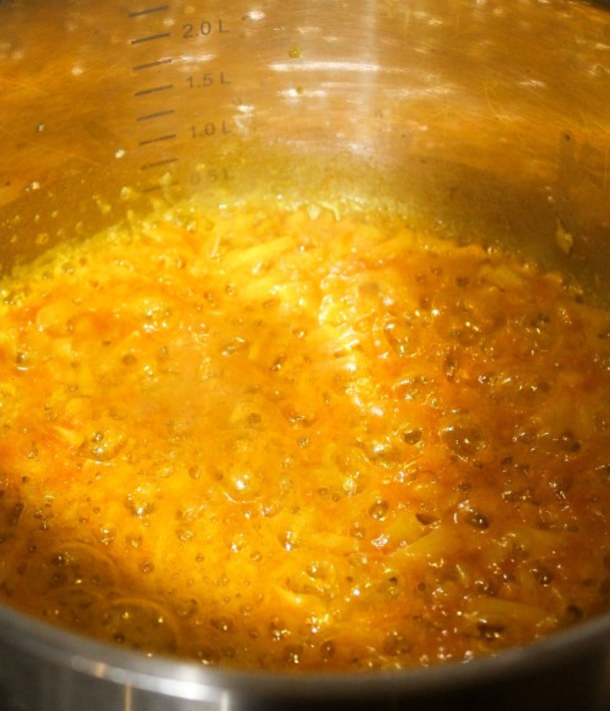 Mixed butter melted, garlic, turmerc and chopped onions in a silver pot.